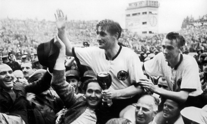 Fritz Walter, tay cầm chiếc cúp Jules Rimet, và Horst Eckel (bên phải) được người hâm mộ khiêng trên vai sau trận chung kết
